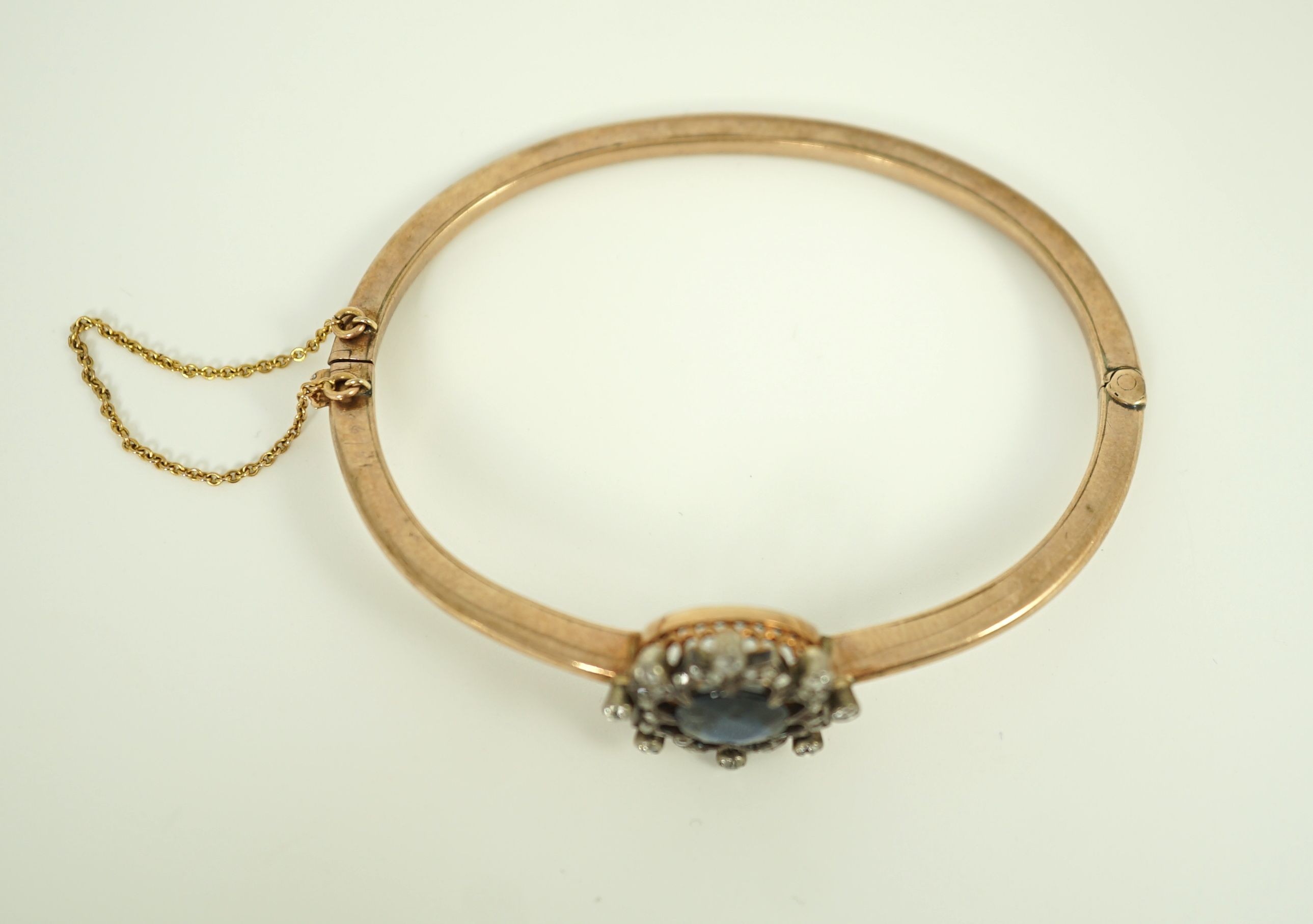 A Victorian gold, sapphire and diamond cluster set hinged bangle
